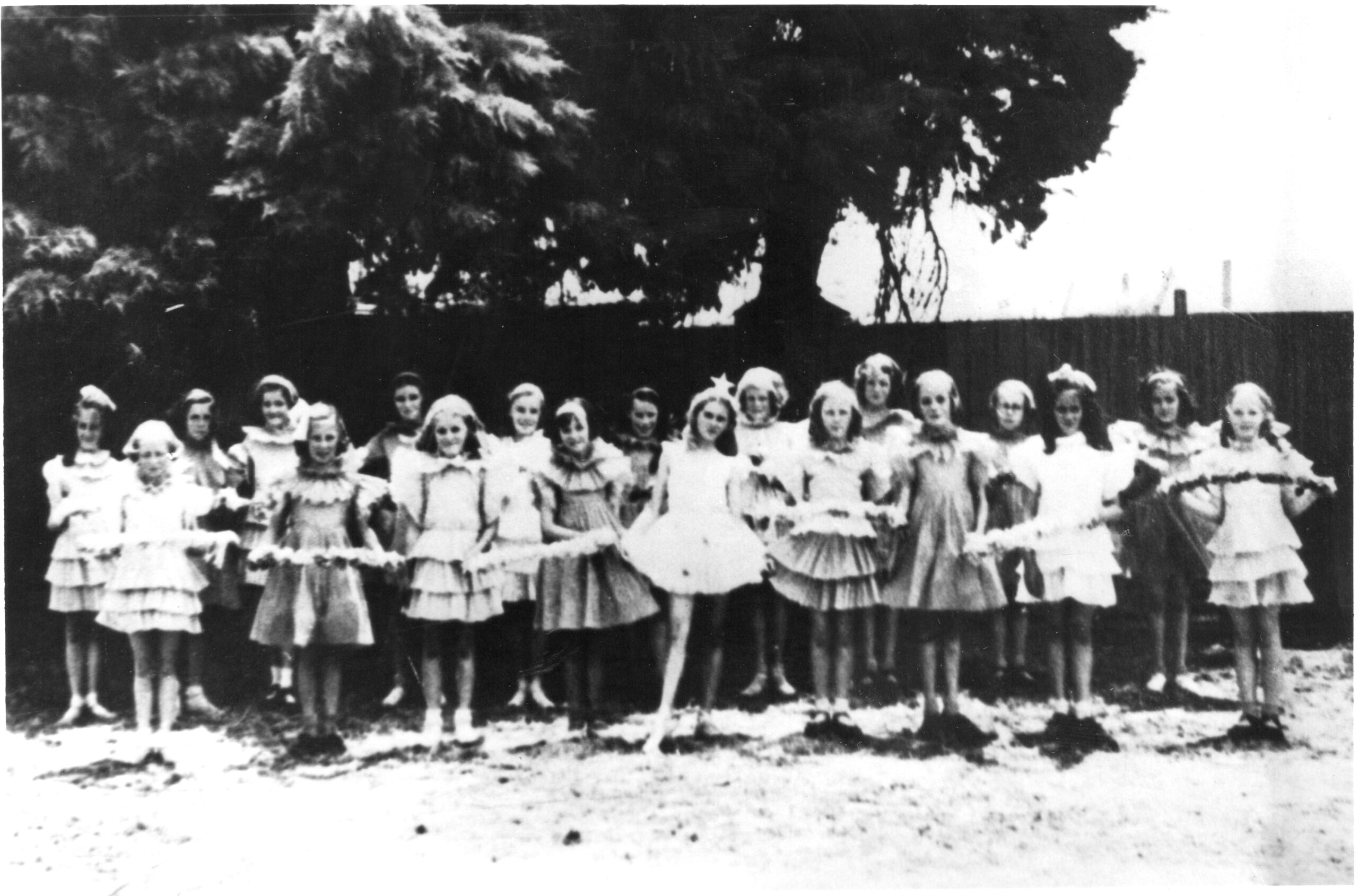 A black and white image of girls in fancy clothing in 1939